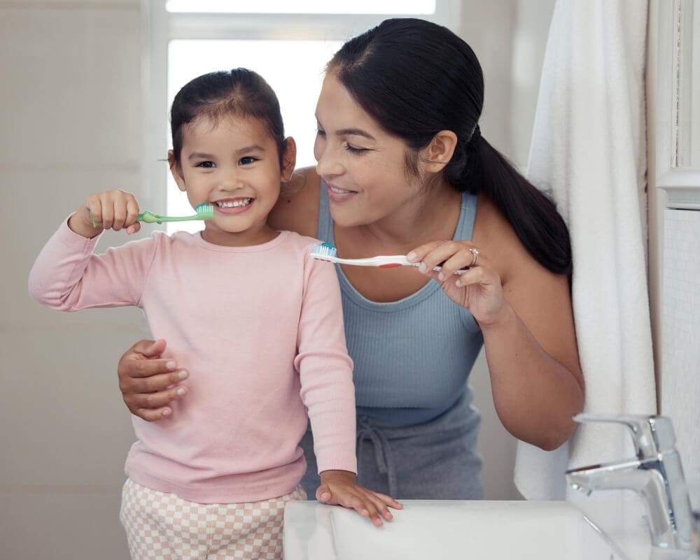 Parent helping young child brush teeth — children's dental care guide in Belmont WA